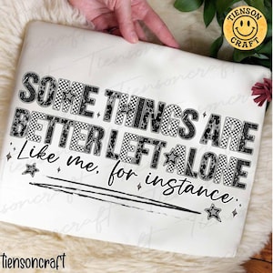 Puede incluir: Un cojín blanco con la frase "SOME THINGS ARE BETTER LEFT ALONE, Like me, for instance." en letras negras, a cuadros y con estrellas. El diseño incluye una línea negra y acentos de estrellas. Se ve un logotipo amarillo con una carita sonriente.