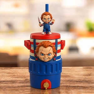 May include: A blue and red beverage cooler featuring a Chucky character design. The lid includes a small Chucky figurine holding a knife, while the main body displays a large Chucky face with red, white, and blue stripes and a blue base with a spigot.