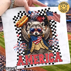 May include: White square featuring a raccoon wearing heart-shaped sunglasses, a patriotic scarf, and a colonial-style jacket, holding a hot dog and an American flag. The word "AMERICA" is in red block letters. Fireworks and a checkered border complete the design.