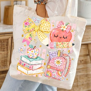 Pu&ograve; includere: Una borsa tote in tela color crema con una stampa grafica colorata. Il design include un grande fiocco a quadretti gialli, una pila di tre libri sormontata da una mela floreale, un cuore color pesca sorridente e uno zaino rosa con una margherita.