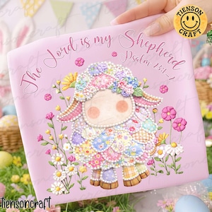 Puede incluir: Un objeto rosa de forma cuadrada con una ilustración de oveja patchwork. El texto dice "The Lord is my Shepherd" y "Salmo 23:1-2". La oveja está adornada con flores.