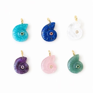 Puede incluir: Seis colgantes en forma de espiral tallados en diversas piedras preciosas, incluyendo turquesa, lapislázuli azul, cuarzo transparente, amatista morada, cuarzo rosa pálido y aventurina verde, cada uno con una pequeña anilla dorada y una piedra central.