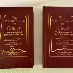 以下が含まれることがあります： 金色の文字が入った2冊のマルーン色の本。タイトルは「The Second Coming of Christ」、サブタイトルは「The Resurrection of the Christ Within You」です。著者はパラマハンサ・ヨガナンダです。巻1と巻2が見えます。