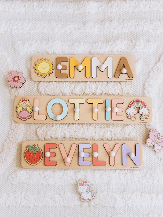 Hand-painted wooden name puzzle with pegs — each letter is a chunky, grabbable piece that doubles as nursery decor, and 204 favorites confirms real parent demand.