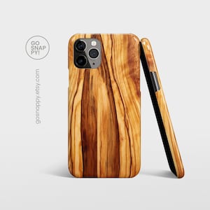 May include: A wood grain phone case with a brown, yellow, and orange color scheme. The case has a raised camera bump and a black side.