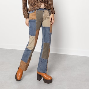 May include: A long-sleeved leopard print blouse with a ruffled front placket paired with patchwork denim jeans featuring various shades of blue denim and tan fabric panels. The outfit is completed with tan platform boots with block heels.