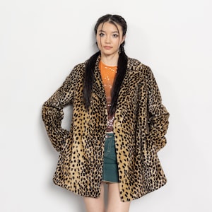 May include: A leopard print coat with a double-breasted design. The coat features a classic collar and a mid-thigh length. The coat's pattern is a mix of black spots on a tan background. The coat is made of a soft, faux fur material.