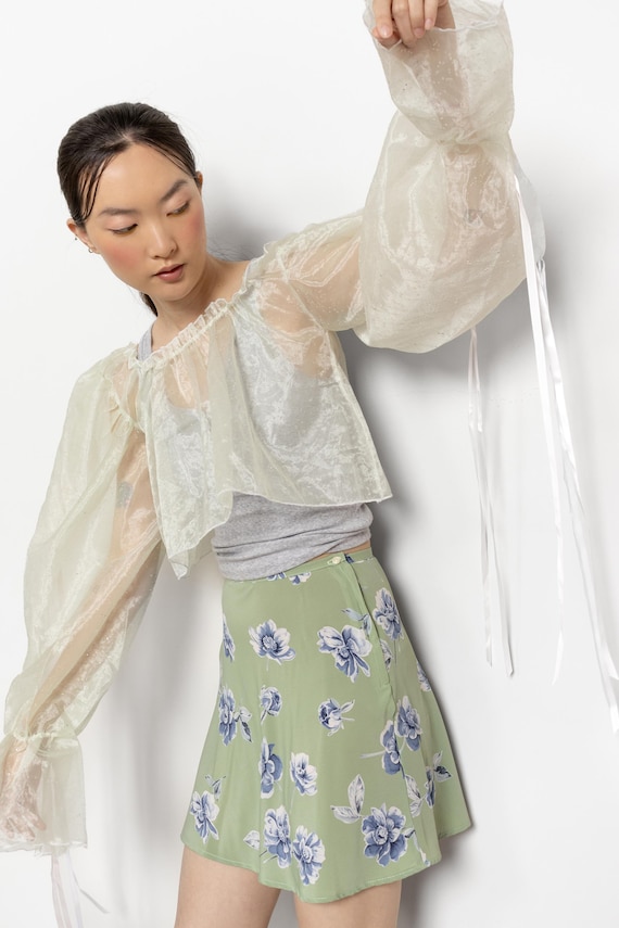 Ameri VINTAGE　SHEER OFF SHOULDER BLOUSE white off-the-shoulder blouse features a unique design with an