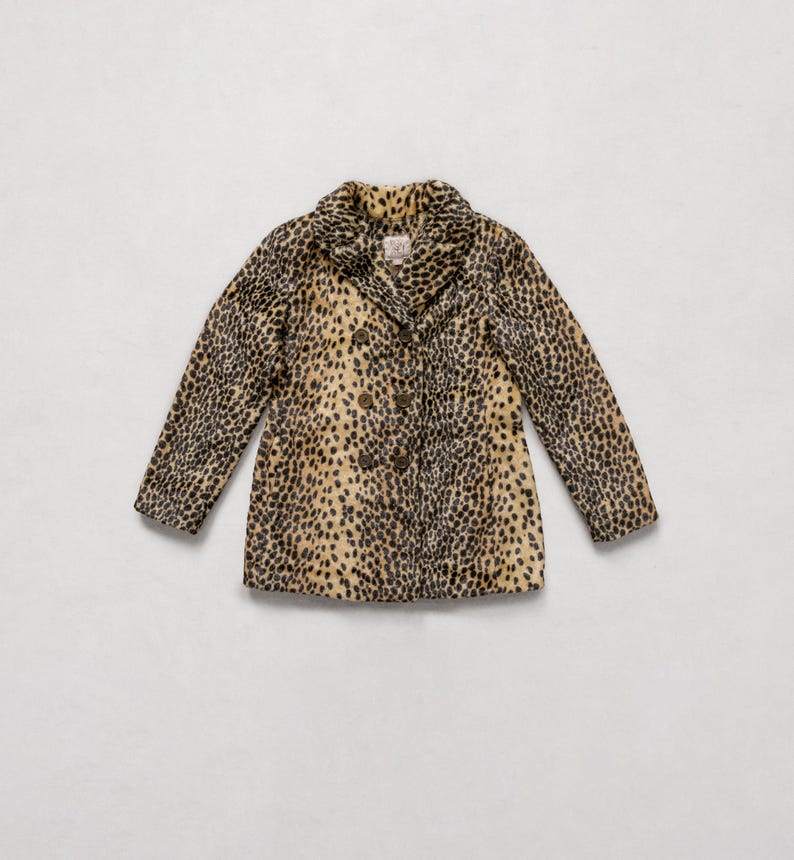 May include: A double-breasted coat with a leopard print pattern. The coat features a notched collar, long sleeves, and a button closure. The coat's colors include tan, black, and brown.