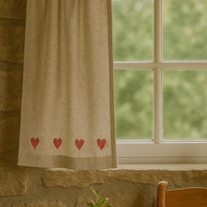 Könnte beinhalten: Beigefarbener Leinen-Vorhang mit vier roten Herz-Applikationen am unteren Rand. Der Vorhang hängt vor einem Fenster mit Blick auf grünes Laub. Der Vorhang hängt vor einer Steinmauer.