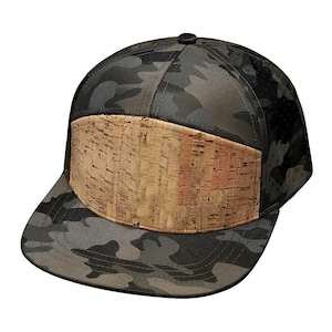 May include: A camouflage patterned baseball cap with a cork panel on the front. The cap has a black brim and a black top.