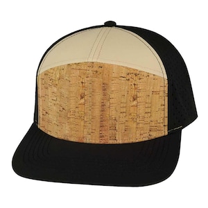 May include: A black and beige baseball cap with a cork panel on the front. The cap has a mesh back and a curved brim.