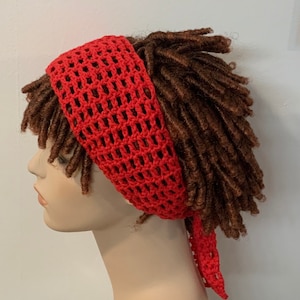 May include: Red crochet headband with a tie at the back. The headband is worn on a mannequin with brown dreadlocks.