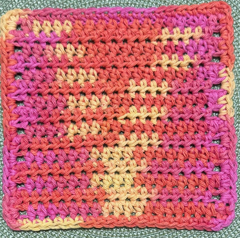 May include: A square crochet coaster featuring a variegated yarn pattern in shades of bright pink, orange, and pale yellow. The textile displays a consistent, dense stitch texture throughout, creating a uniform surface with a repeating color gradient.