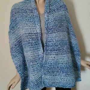 May include: A blue and white crocheted shawl with a gradient pattern. The shawl is draped over a mannequin.