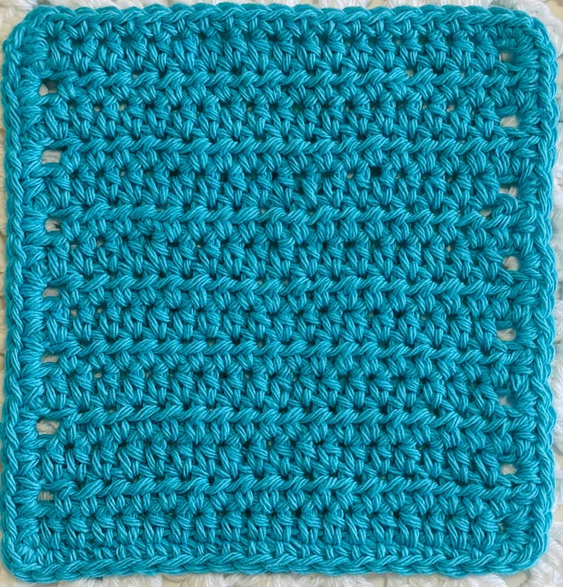 May include: A square-shaped, bright turquoise crochet piece featuring a consistent, dense stitch pattern. The edges are defined by a series of evenly spaced, small rectangular openings that create a border around the solid, textured center.
