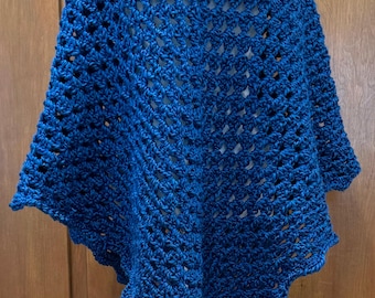 Puede incluir: Un poncho de ganchillo azul con un patrón de encaje. El poncho está en un maniquí blanco.