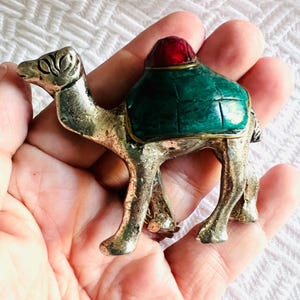 Statuetta vintage di cammello in argento con sella dipinta di rosso e verde, 2x2 pollici