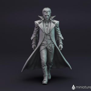 Op de afbeelding: Een grijs 3D-geprint miniatuur van een man die een lange jas met een hoge kraag en een riem draagt. Hij heeft een serieuze uitdrukking op zijn gezicht en houdt zijn handen voor zich.