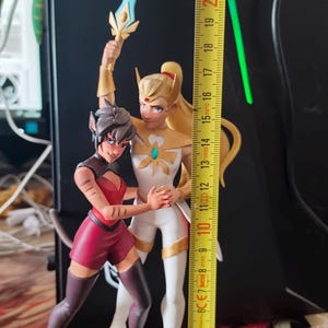 K&ouml;nnte beinhalten: Detaillierte Figur von zwei animierten Charakteren, von denen einer ein Schwert h&auml;lt. Die Figur ist etwa 20 cm hoch. Die Charaktere befinden sich in dynamischen Posen, einer in einem wei&szlig;-goldenen Outfit, der andere in Rot und Schwarz.