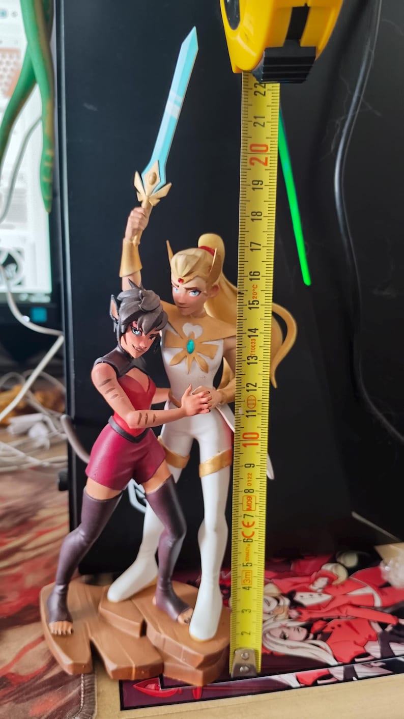 K&ouml;nnte beinhalten: Detaillierte Figur von zwei animierten Charakteren, von denen einer ein Schwert h&auml;lt. Die Figur ist etwa 20 cm hoch. Die Charaktere befinden sich in dynamischen Posen, einer in einem wei&szlig;-goldenen Outfit, der andere in Rot und Schwarz.