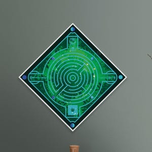 May include: A green and blue geometric wall art piece featuring a maze design. The artwork is diamond-shaped with a white border and is hanging on a gray wall. A wooden cabinet with books, a glass jar, and a candle sits below.