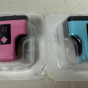 May include: Two ink cartridges, one pink and one blue, each in a clear plastic package. The cartridges have a black top and a black label with the number "02" and a diamond symbol.