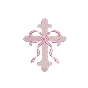 May include: A light pink embroidered cross with a pink bow. The cross has a detailed, textured design and is set against a white background. The bow is tied at the center of the cross and has flowing ribbons.