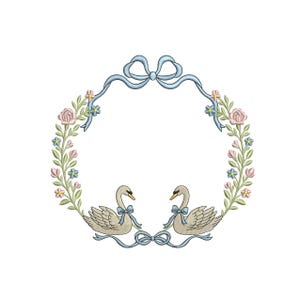 May include: An embroidered design featuring two swans facing each other, adorned with light blue bows. The swans are surrounded by a floral wreath of pink roses, blue and yellow flowers, and green leaves, all framed by a light blue ribbon.