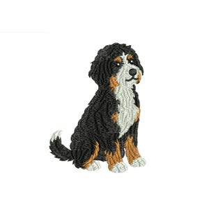 May include: Embroidered image of a Bernese Mountain Dog puppy, sitting upright. The dog has black, white, and brown fur, with a fluffy appearance. The dog's tail is curled, and it has a friendly expression. The background is plain white.