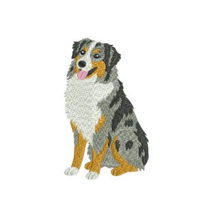 May include: An embroidered image of a sitting Australian Shepherd dog. The dog has a mix of gray, black, white, and tan fur. Its tongue is pink, and its eyes are dark. The dog is sitting upright with its front paws forward.