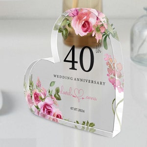 Könnte beinhalten: Eine transparente, herzförmige Acryl-Plakette mit einem Blumendesign und dem Text "40. Hochzeitstag David & Anna 07.07.2024".
