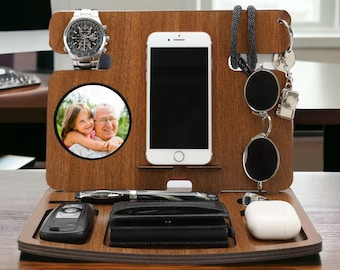 May include: A wooden organizer with compartments for a phone, watch, keys, glasses, and a wallet. It also has a small photo frame with a picture of a man and a girl.