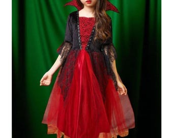 May include: A red and black vampire costume for children. The dress features a red skirt with a black lace overlay, a black velvet bodice, and a high collar. The sleeves are adorned with black lace.