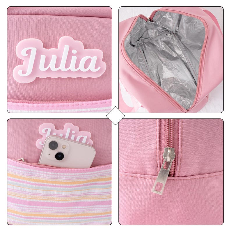May include: Pink insulated lunch bag with the name "Julia" in white script. The bag has a zippered closure, a front pocket with a striped pattern, and a silver insulated interior. A smartphone is visible in the front pocket.