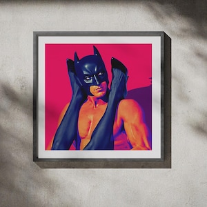 Puede incluir: Impresión artística enmarcada. Imagen de estilo pop art de una persona con una máscara de Batman sosteniendo tacones altos negros. El fondo es rosa vibrante, con un marco gris.