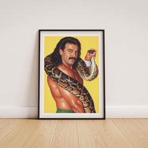 May include: A framed art print featuring a portrait of a person with long dark hair and a moustache, shirtless, with a large patterned python snake draped around their shoulders and neck against a solid bright yellow background.