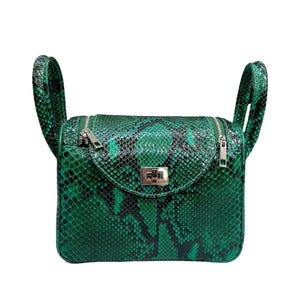 May include: A green and black snakeskin-patterned handbag with two curved handles. The bag has a rectangular shape with a curved flap and a silver-toned clasp. A silver zipper runs across the top.