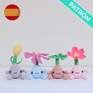 May include: Four crocheted flower-shaped dolls in pastel colors. Each doll has a different flower on top, including yellow, pink, and green. The dolls have smiling faces and small arms and legs. The word "PATRÓN" is in the image.
