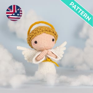 May include: A crocheted angel doll with a yellow halo, hair, and sash. The doll has white wings and a white dress. The doll is set against a backdrop of fluffy white clouds and a light blue sky. The word "PATTERN" is in a green box.