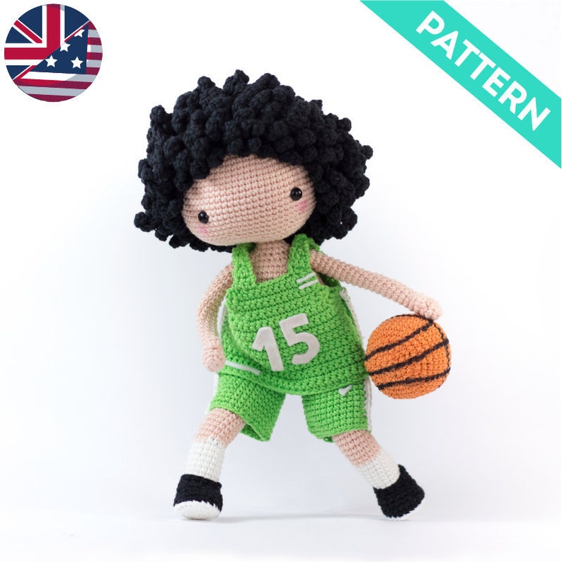 May include: Crocheted amigurumi doll wearing a green basketball uniform with the number 15 on the front. The doll is holding an orange basketball.