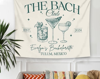May include: A white tapestry with the text "The Bach Club Est. 2024" and "Evelyn's Bachelorette Tulum, Mexico". The tapestry features three illustrations of cocktails, including a martini, a margarita, and a mixed drink with a lime wedge.