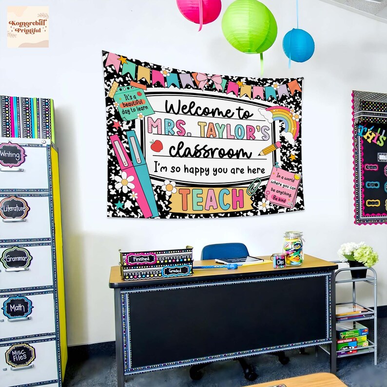 Puede incluir: Escena de aula con un tapiz que dice "Bienvenida a la clase de la Sra. Taylor". El tapiz est&aacute; decorado con ilustraciones coloridas. Tambi&eacute;n se ven un escritorio, archivadores y faroles de papel.
