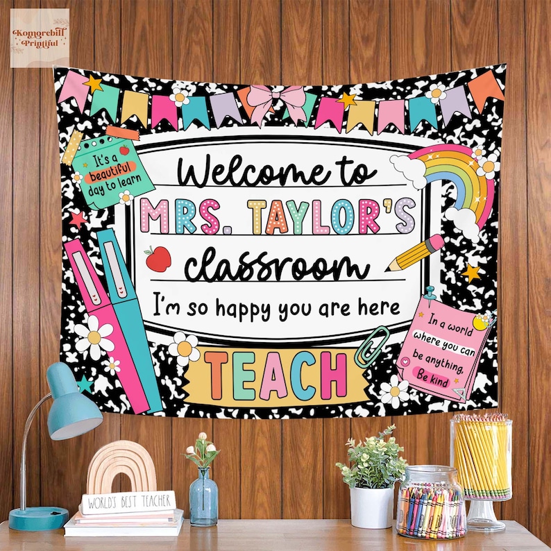 Puede incluir: Un tapiz de aula con el texto "Welcome to MRS. TAYLOR'S classroom." El dise&ntilde;o incluye un arco&iacute;ris, l&aacute;pices y las palabras "TEACH" y "Be kind." El fondo es blanco y negro con elementos florales y de papel de cuaderno.
