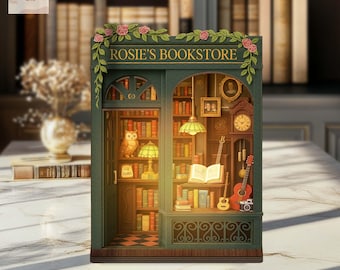 May include: A miniature bookstore diorama with the text "Rosie's Bookstore" above the entrance. The green facade features shelves filled with books, an owl figurine, a guitar, and a grandfather clock. Pink roses and green leaves decorate the top.