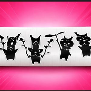 May include: A white rectangular sheet featuring four distinct black die-cut stickers. Each sticker displays a stylized silhouette of a forest creature with plant-like features, including branches, leaves, and rounded heads, arranged in a horizontal row.