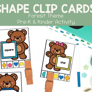 May include: Shape clip cards with a forest theme for Pre-K and Kinder activities. The cards feature cartoon bears holding shapes like squares and stars. Wooden clothespins are attached to the cards. A teal notebook, pen, candle, and plant are also visible.
