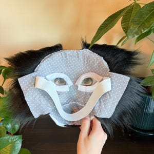 Puede incluir: Una m&aacute;scara de mono hecha a mano con una cara de lunares grises y blancos, pelo negro y correas el&aacute;sticas. La m&aacute;scara presenta recortes de ojos detallados y est&aacute; dise&ntilde;ada para uso en disfraces o cosplay.