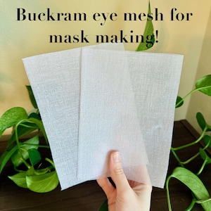 Peut inclure: Trois feuilles de tissu en maille oculaire de buckram blanc pour la fabrication de masques sont pr&eacute;sent&eacute;es devant un fond de verdure. Le texte "Buckram eye mesh for mask making!" est &eacute;crit en noir en haut de l'image.