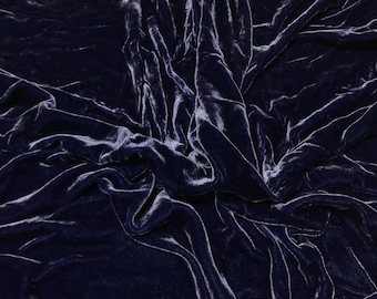 Può includere: Primo piano di un tessuto di velluto blu scuro con una texture morbida e lussuosa. Il tessuto è drappeggiato e piegato, creando un aspetto drammatico ed elegante.